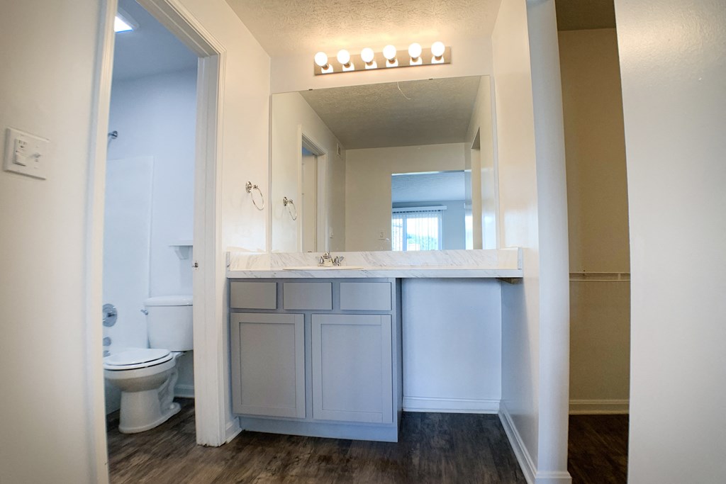 a bathroom with a sink and a toilet and a mirror  at Knobs Pointe Apartments, New Albany, IN, 47150
