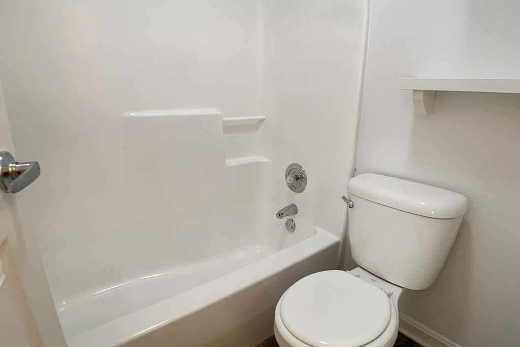 an empty bathroom with a toilet and a tub  at Knobs Pointe Apartments, New Albany, 47150