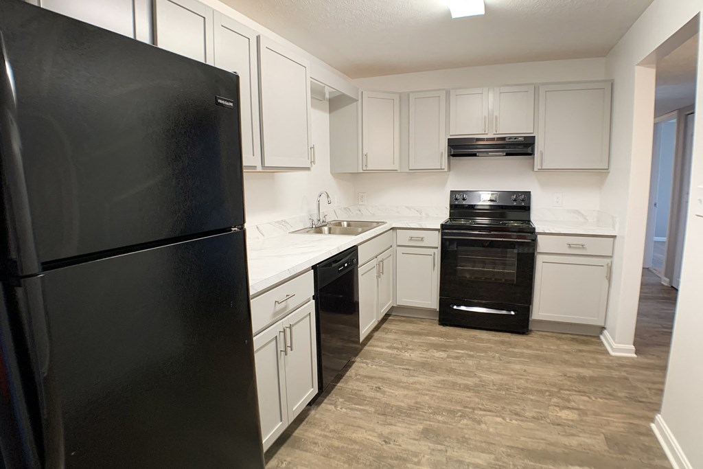 an empty kitchen with white cabinets and black appliances  at Knobs Pointe Apartments, New Albany, IN