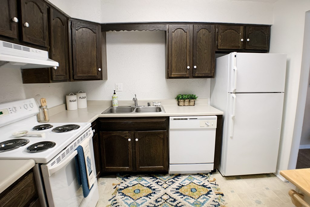 a kitchen with white appliances and brown cabinets and a white refrigerator at Knobs Pointe Apartments, New Albany, Indiana