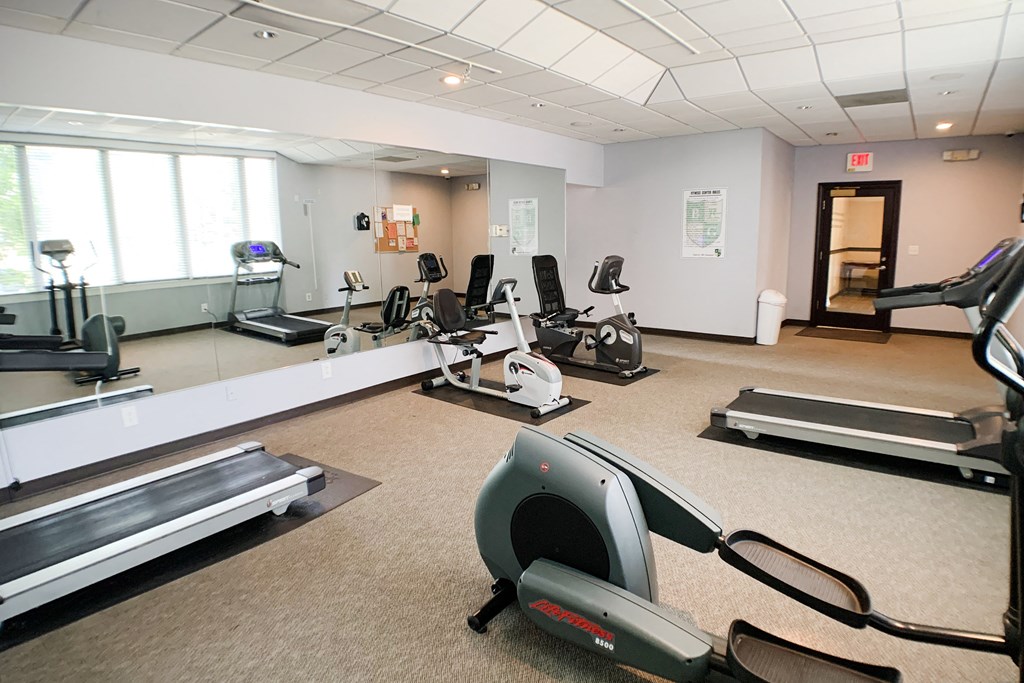 a gym with treadmills and other exercise equipment in a building with windows  at Knobs Pointe Apartments, New Albany