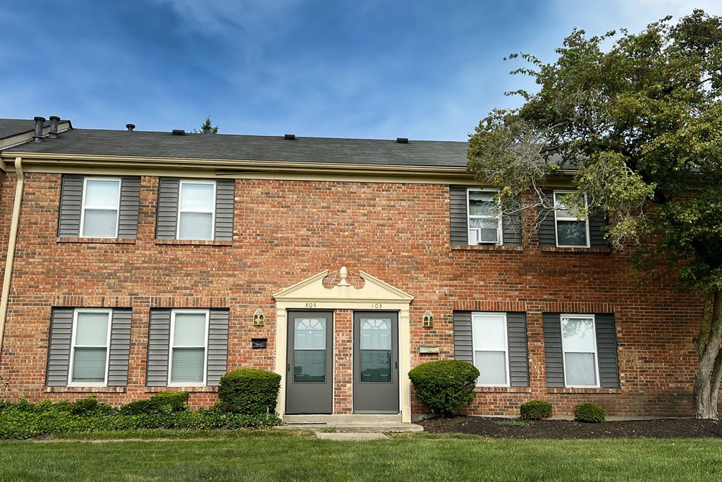 the front of a brick building with a blue door at Revere Village Apartments, Ohio, 45458
