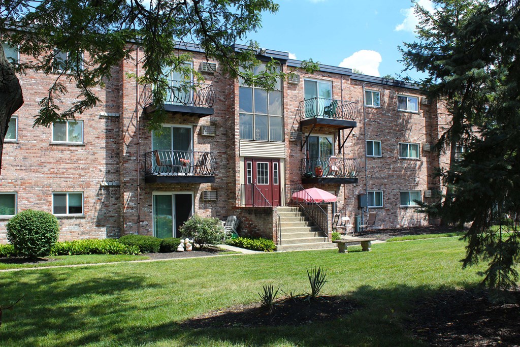 A large brick building with a red awning and a balcony.