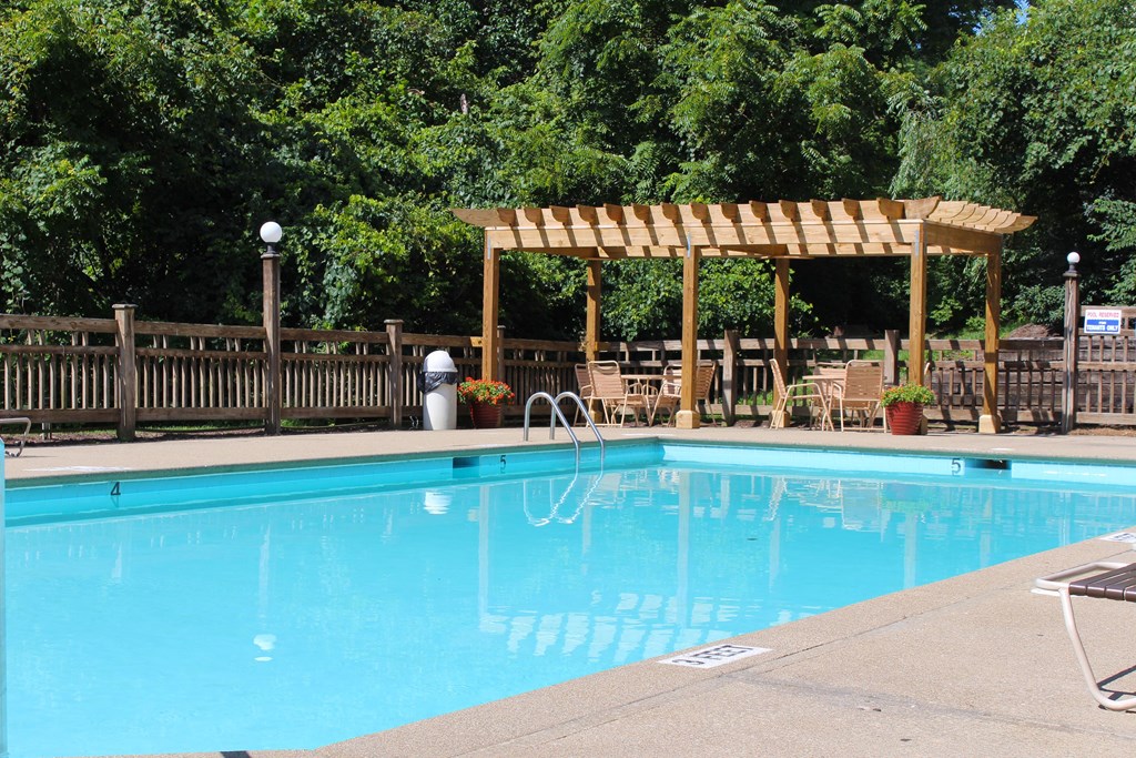 a swimming pool with a wooden canopy next to a resort pool at The Vinings Apartments, Cincinnati, 45245