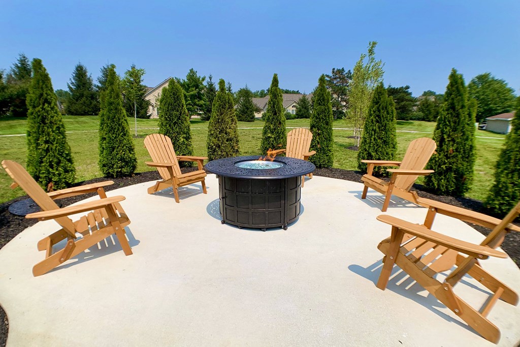 a patio with a fire pit and wooden chairs at Steeplechase Apartments, Loveland, 45140
