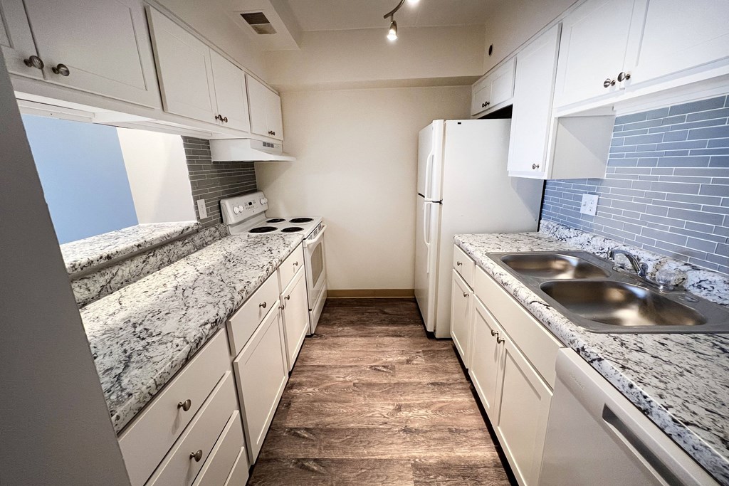 a kitchen with white cabinets and granite countertops at Indian Lookout Apartments, Ohio