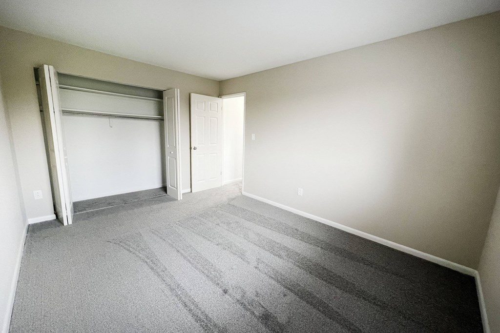 an empty bedroom with a closet and an open door at Wentworth Estates Apartments, Florence, KY