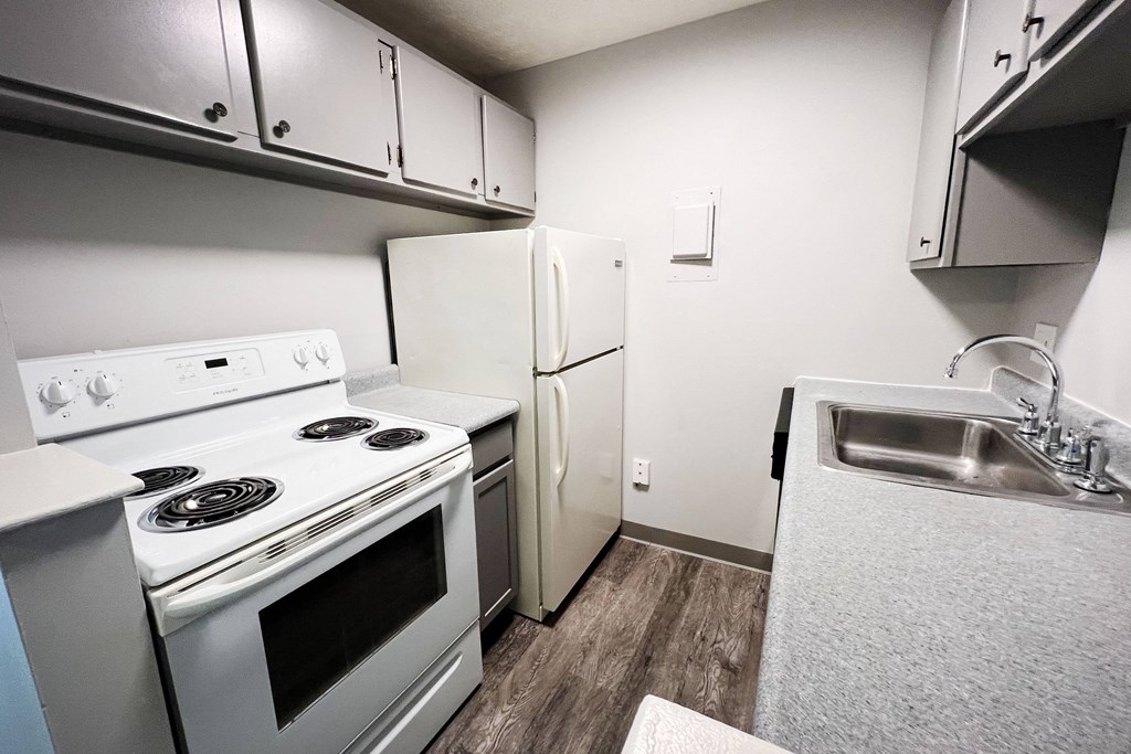 a kitchen with white appliances and white cabinets  at Summit East - A Senior Community, Cincinnati, 45237