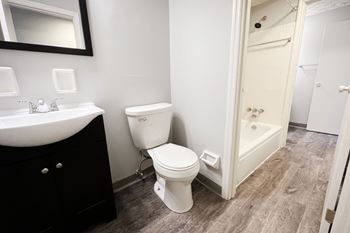 A white toilet sits next to a sink in a bathroom.