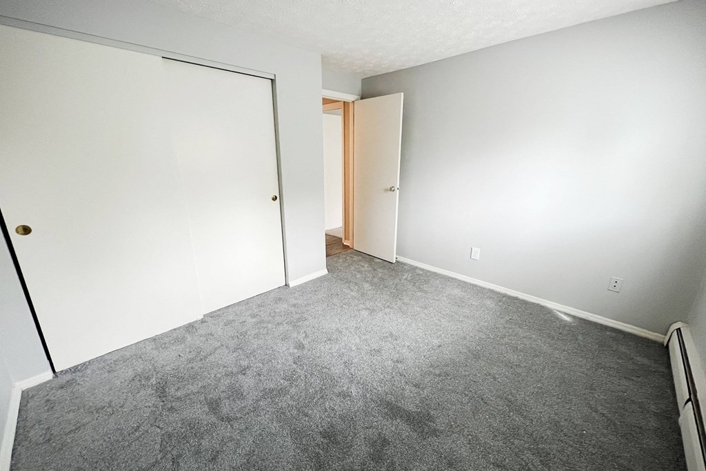 a bedroom with a carpeted floor and an open door  at Summit East - A Senior Community, Ohio, 45237