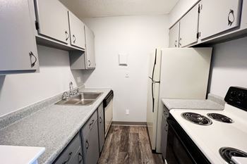 A kitchen with white appliances and grey countertops.