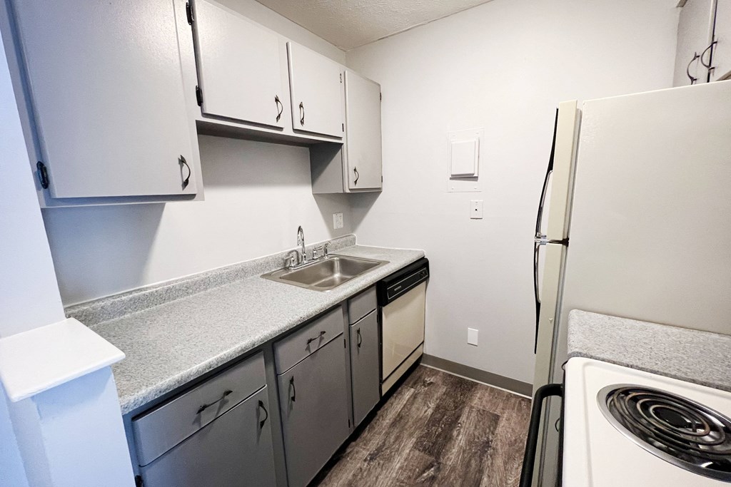 a kitchen with white cabinets and white appliances  at Summit East - A Senior Community, Cincinnati, Ohio