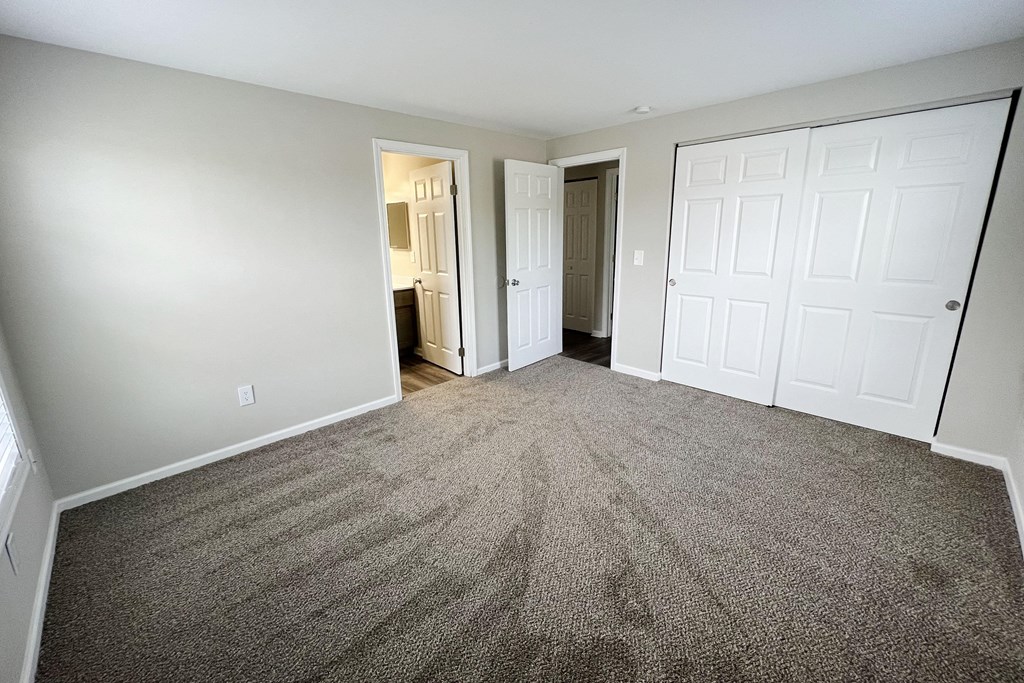 a bedroom with two closets and a door to a bathroom  at Woodhills Apartments, West Carrollton, OH