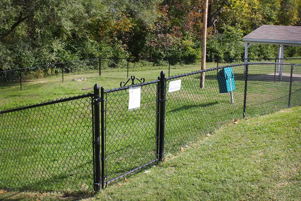 a fence with signs on it in a dog park  at Knobs Pointe Apartments, New Albany, Indiana