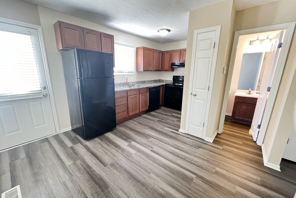 a kitchen with wooden floors and a black refrigerator at The Villas at Kingswood, West Chester, 45069