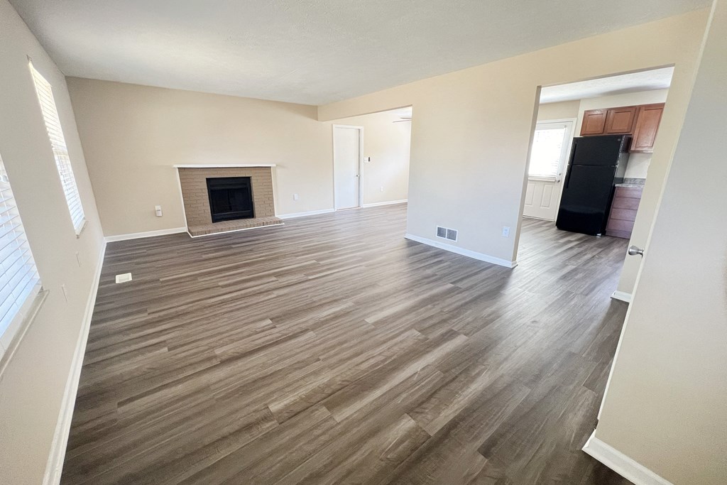 an empty living room with wood flooring and a fireplace at The Villas at Kingswood, West Chester, OH, 45069