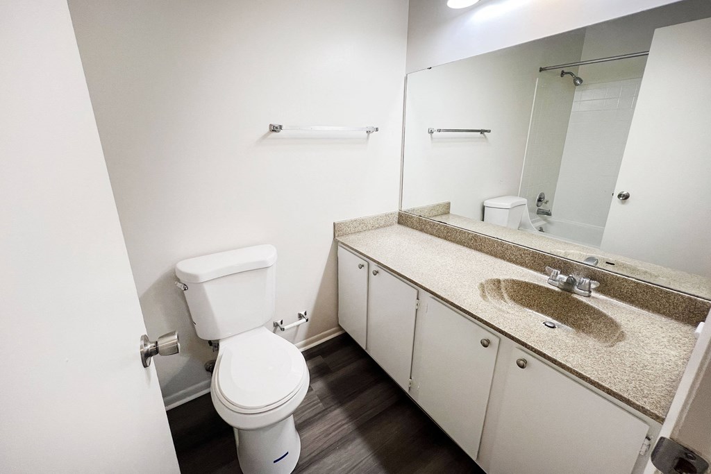 a bathroom with a toilet sink and mirror  at Hunter's Creek Apartments, Ohio