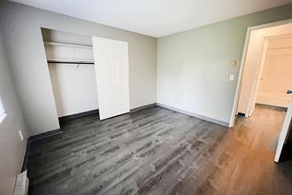 a bedroom with hardwood flooring and a closet