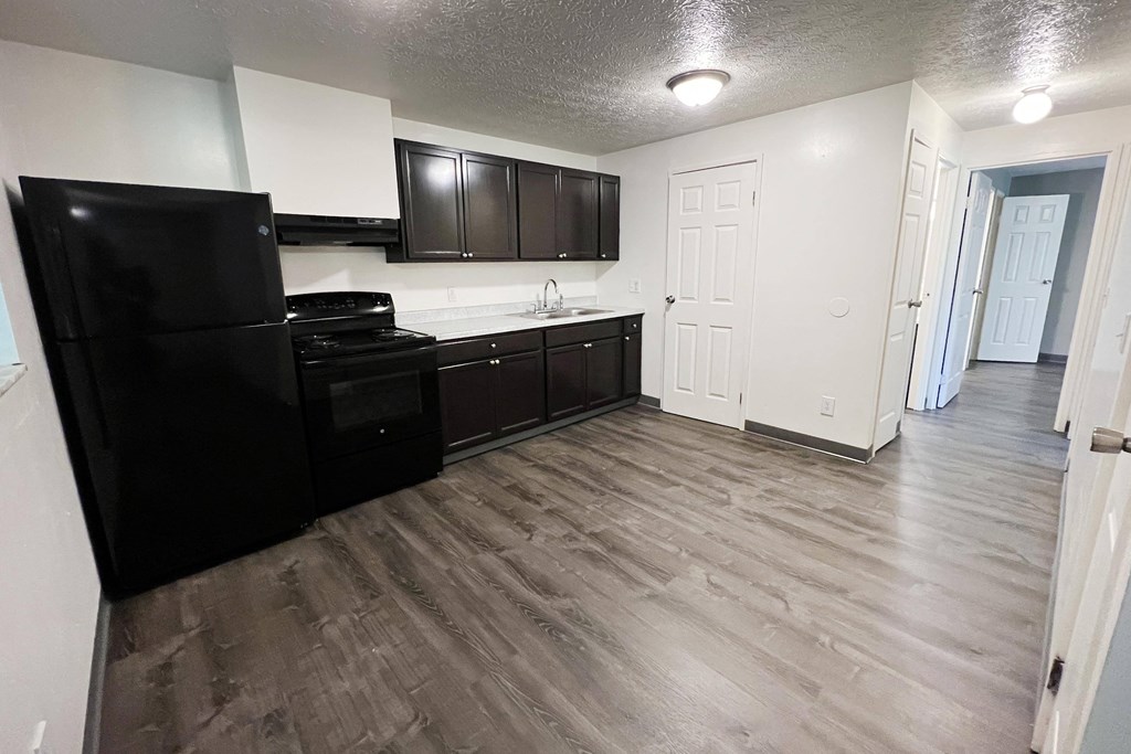 a kitchen with black appliances and white walls at Quail Meadow Apartments, Cincinnati
