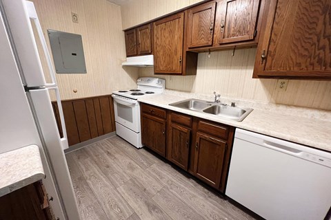 a kitchen with white appliances and wooden cabinets  at Devou Village, Ft. Wright