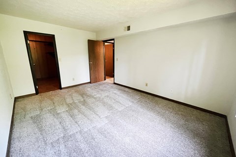 an empty living room with a carpeted floor and two doors  at Devou Village, Ft. Wright, Kentucky