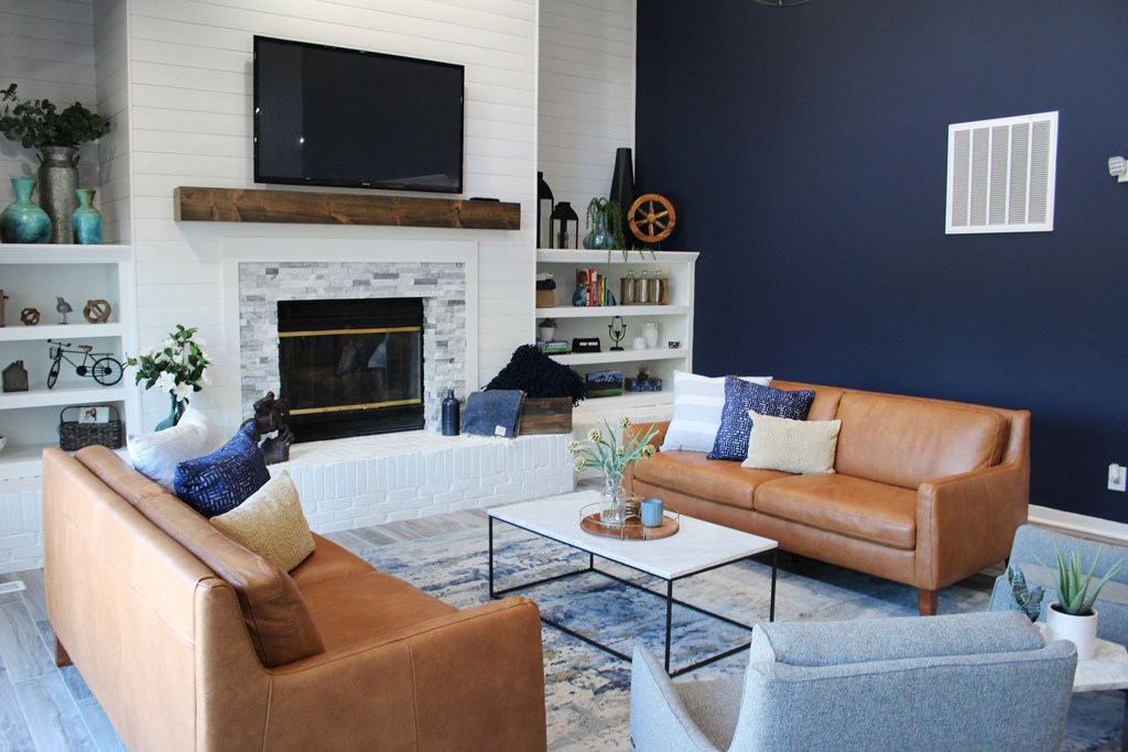 a living room with two leather couches and a fireplace at Steeplechase Apartments, Loveland, 45140