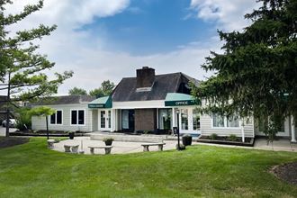 a view of the front of the building with a patio and fire pit