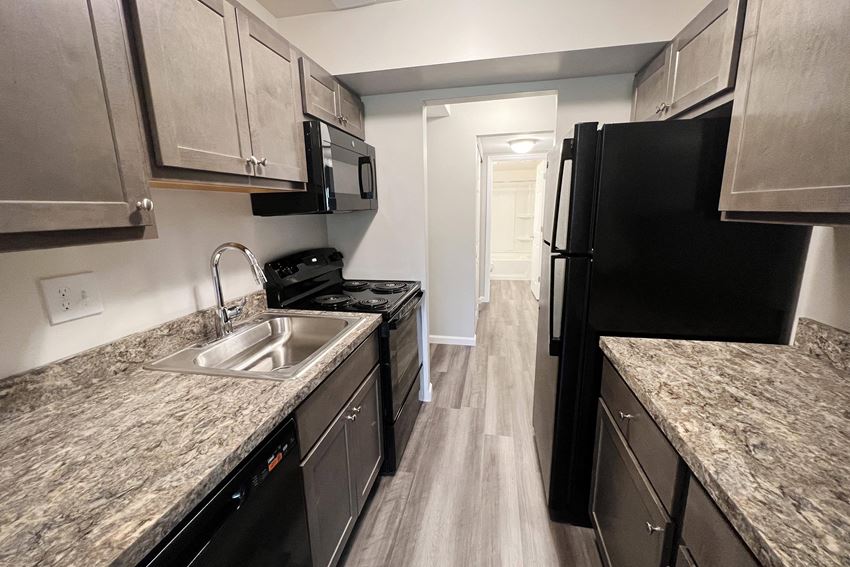 a kitchen with gray cabinets and black appliances