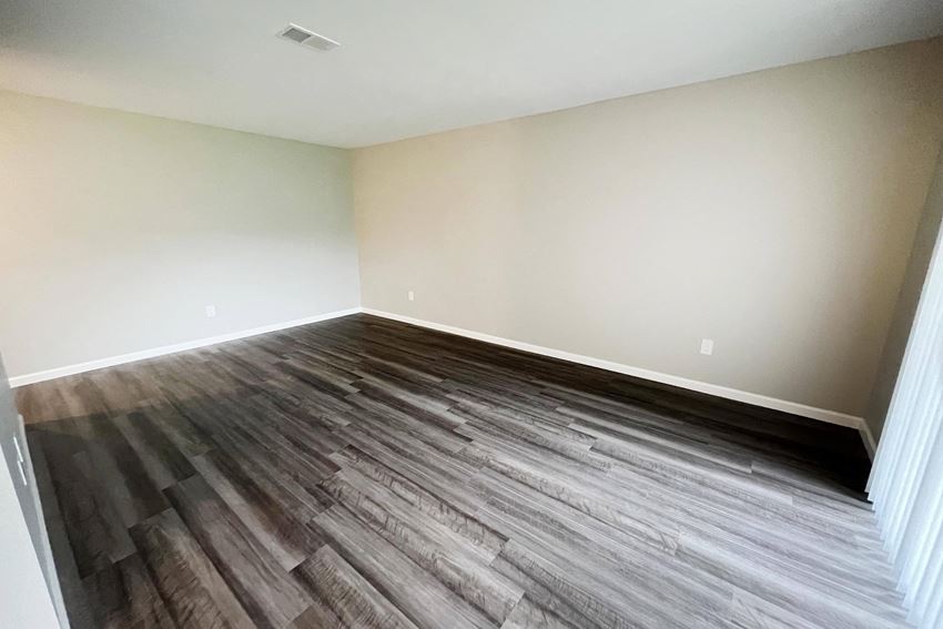 a bedroom with hardwood floors and white walls