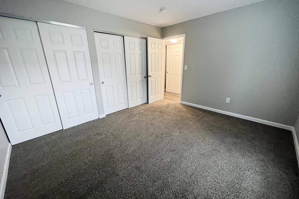 a bedroom with two closets and a door to a bathroom  at Timber Ridge Apartments, Cincinnati, Ohio