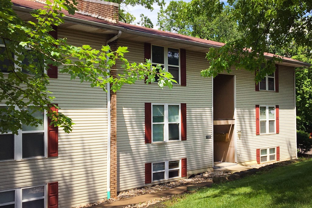 a white house with red shutters and a tree  at Timber Ridge Apartments, Cincinnati, Ohio