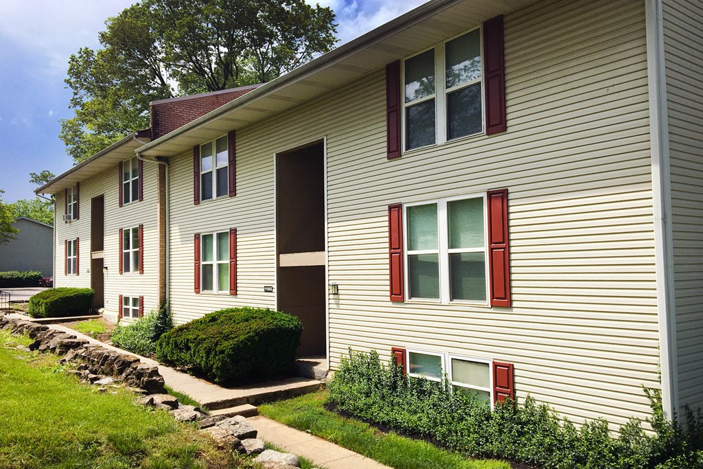 the side of a house with red windows and a sidewalk  at Timber Ridge Apartments, Cincinnati