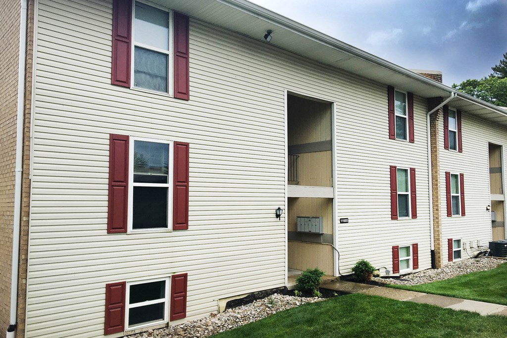 the side of a building with red and white siding and grass at Timber Ridge Apartments, Ohio, 45241