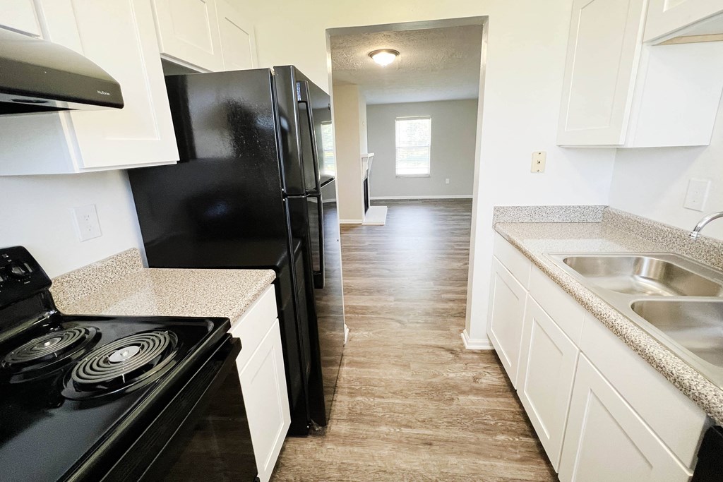 a kitchen with white cabinets and black appliances  at The Villas at Kingswood, West Chester, 45069