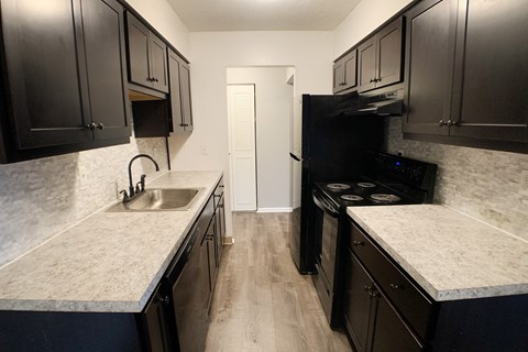 a kitchen with black appliances and white counter tops