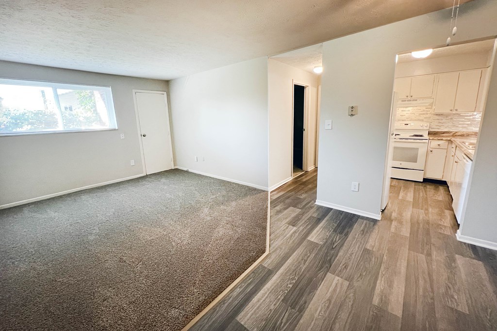 an empty living room and kitchen with wood flooring and a window at Oakwood Apartments, Florence, KY