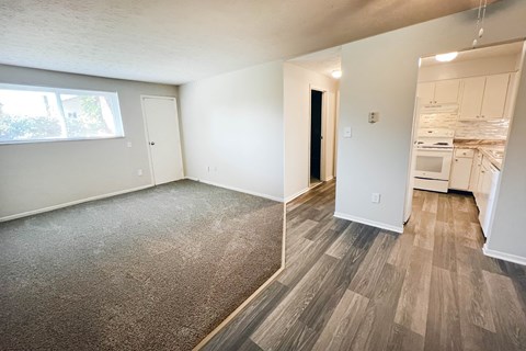an empty living room and kitchen with wood flooring and a window at Oakwood Apartments, Florence, KY