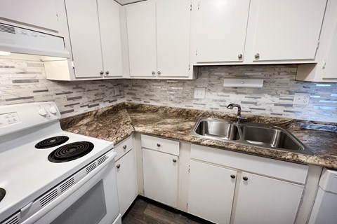 a kitchen with white appliances and granite counter tops at Oakwood Apartments, Florence, Kentucky