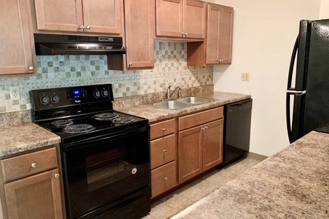 a kitchen with black appliances and wooden cabinets