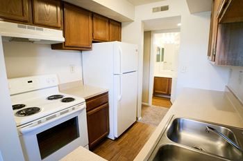 a kitchen with white appliances and wooden cabinets and a white refrigerator at Deercross Apartments, Cincinnati
