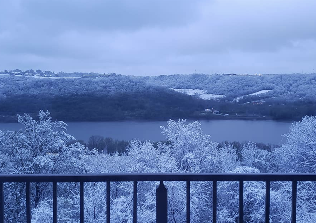 a balcony overlooking a lake and trees in the snow at Indian Lookout Apartments, Cincinnati, OH