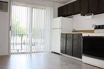 A kitchen with white appliances and a sliding glass door.