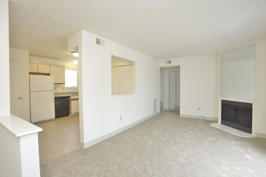 a living room with a fireplace and a kitchen in the background at 450 on Keeneland, Richmond