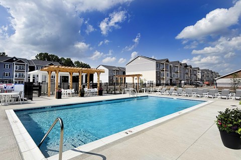 Swimming pool with white lounge chairs and wooden pergolas at The Meridian on 32 Apartments, Ohio, 45103