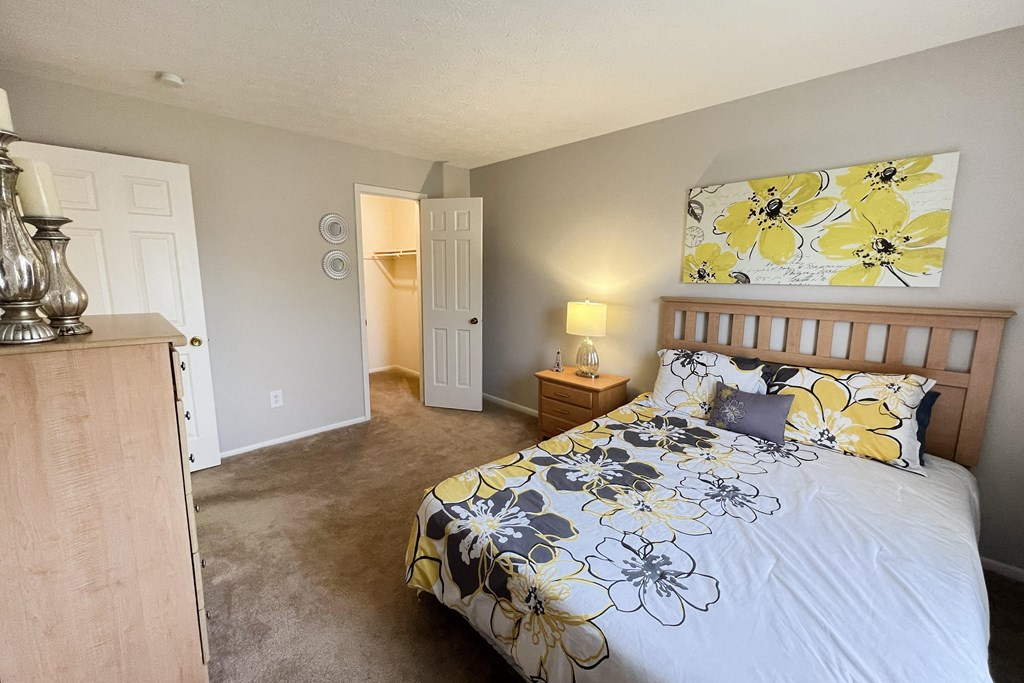 a bedroom with a bed and a door to a bathroomat Revere Village Apartments, Ohio, 45458