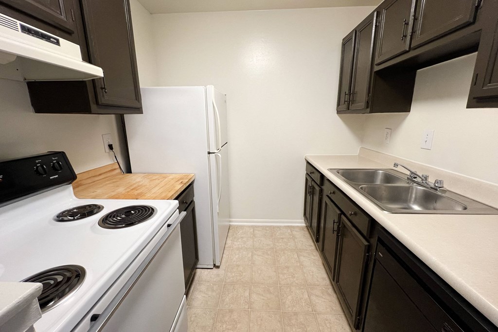 an empty kitchen with a stove sink and refrigerator at Revere Village Apartments, Ohio, 45458