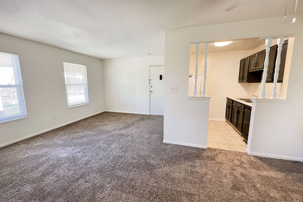an empty living room and kitchen with a carpeted floorat Revere Village Apartments, Ohio, 45458