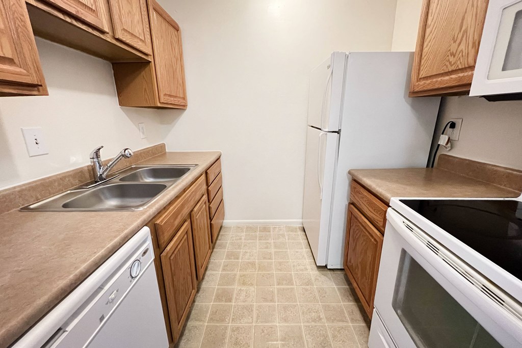 a kitchen with white appliances and wooden cabinetsat Revere Village Apartments, Centerville, Ohio