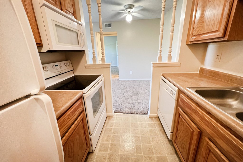 a kitchen with white appliances and wooden cabinetsat Revere Village Apartments, Ohio