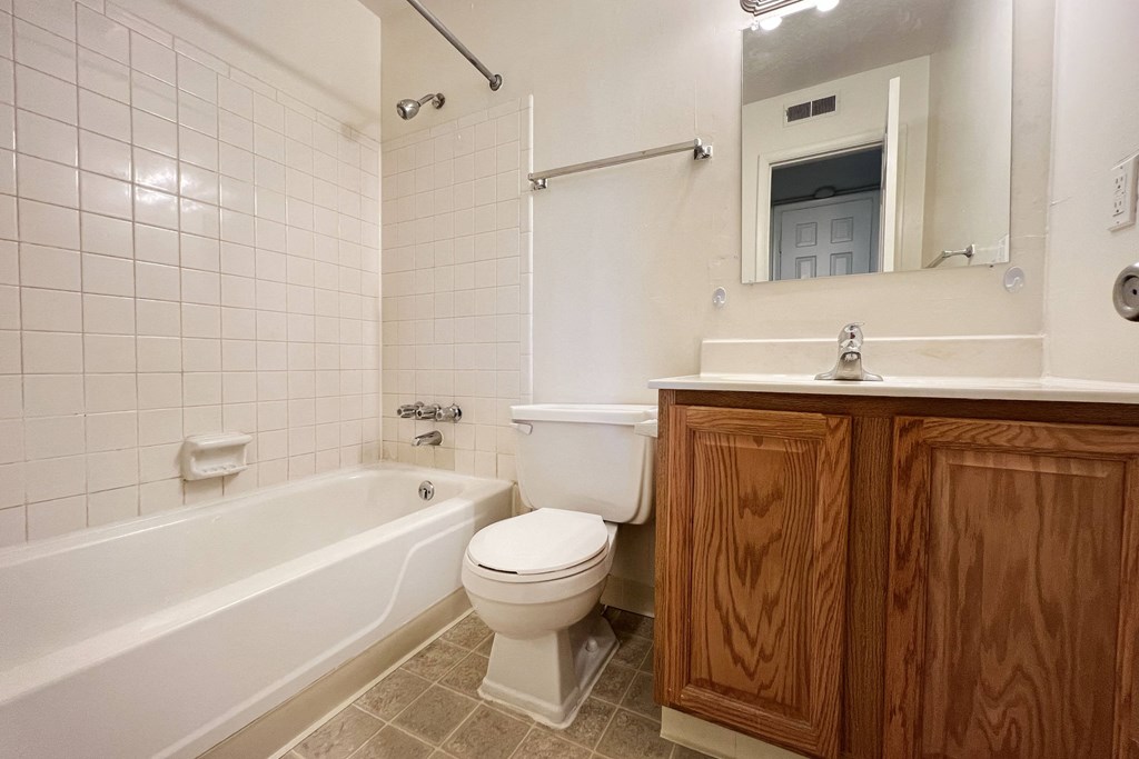 a bathroom with a toilet and a tub and a sinkat Revere Village Apartments, Ohio